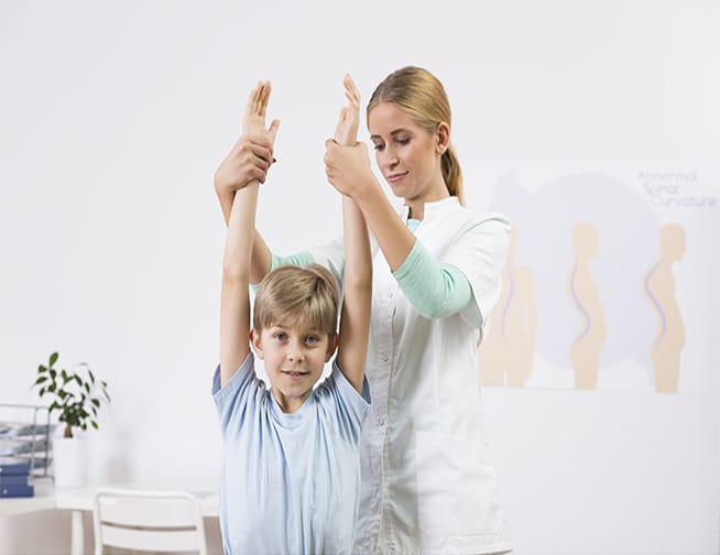 A child exercising under the guidance of a physiotherapist at Denton Family Practice Clinic.